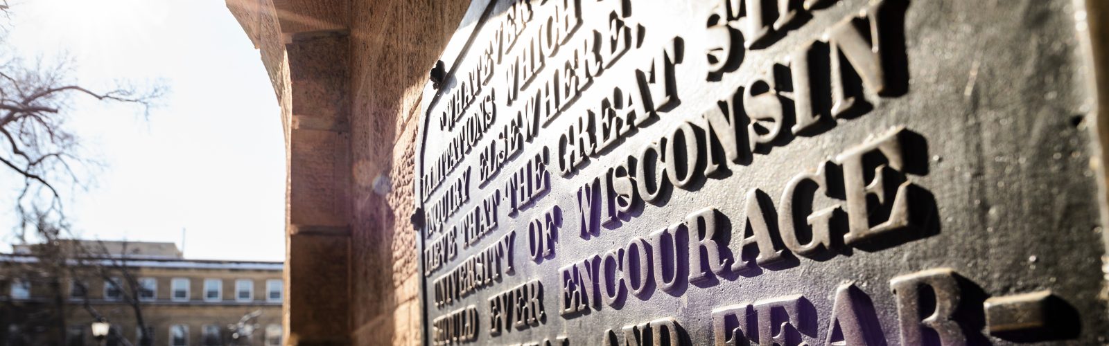 Dark metal plaque on exterior of building with the words of UW-Madison's sifting and winnowing statement